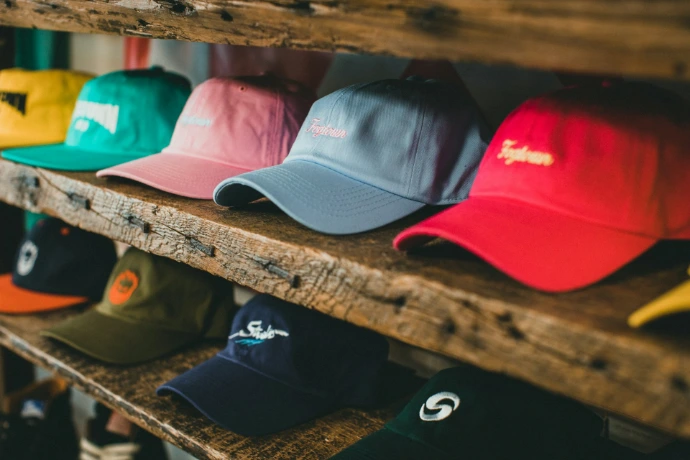 a row of hats sitting on top of a wooden shelf